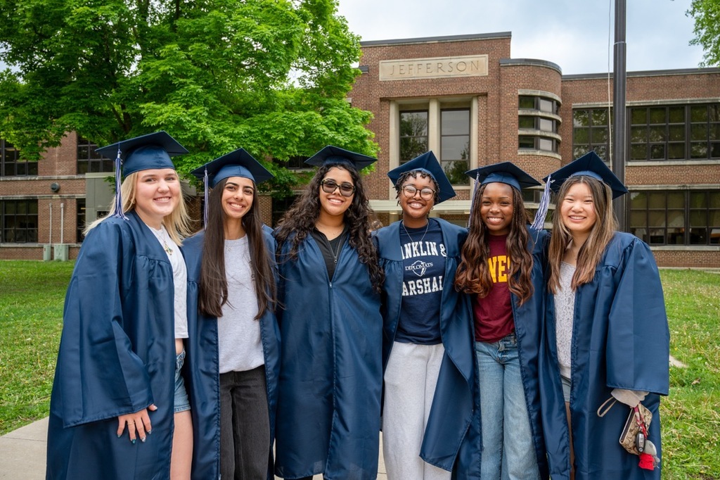 Group of six senior students posing in front of Jefferson Elementary smiling at the camera.