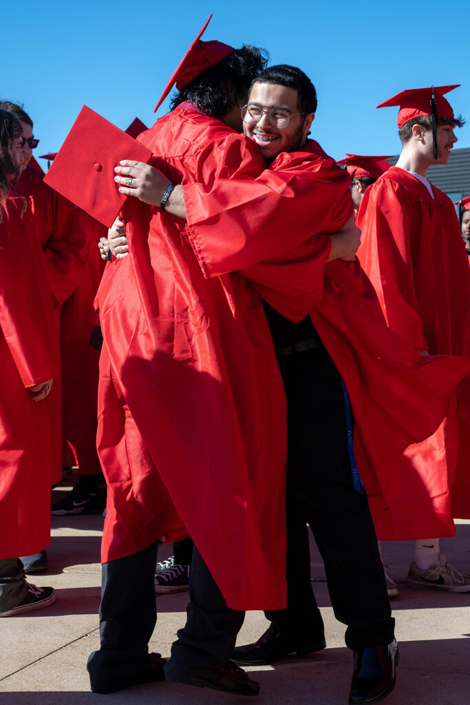Two JM students embracing for a hug in excitement for graduation.