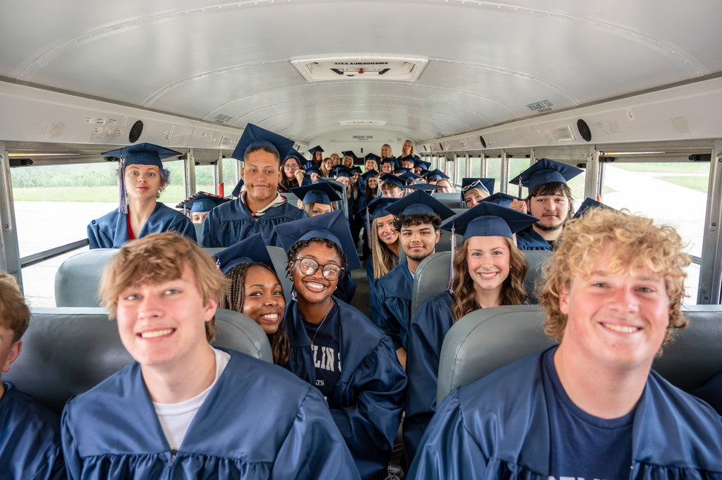 Century seniors loaded on the bus in cap and gown for the senior walk-through