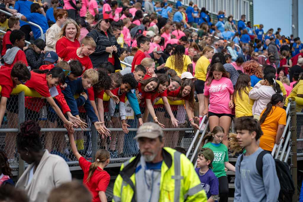 Students high fiving students as they return back to the bleachers.