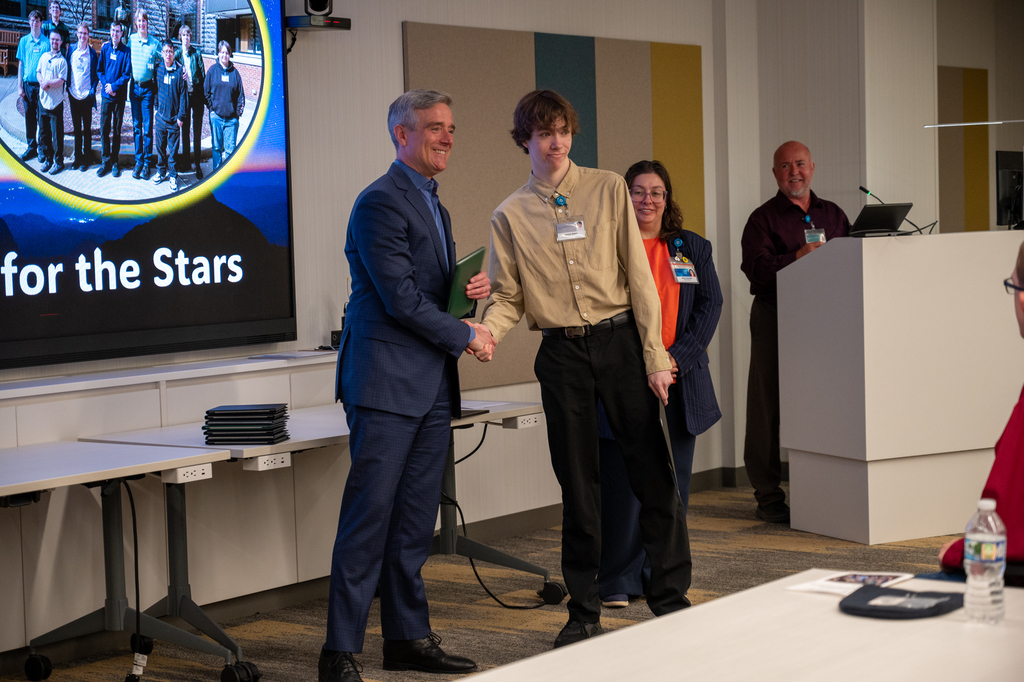Superintendent Pekel shaking hands with a graduate