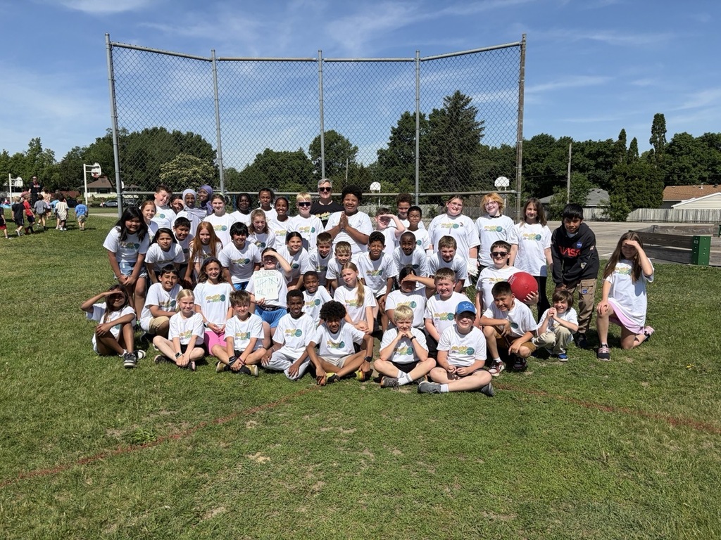 Elton Hills 5th Grade Class standing in a group posing for a photo in front of the backstop on the playground.