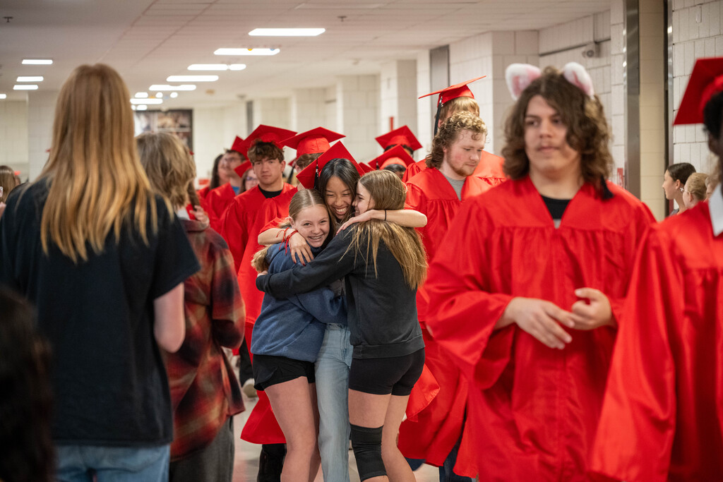 JM senior stopping to hug their friends in the hallway.