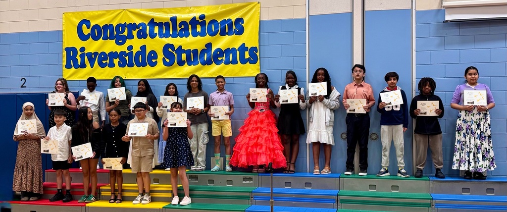 Children standing on a stage with certificate