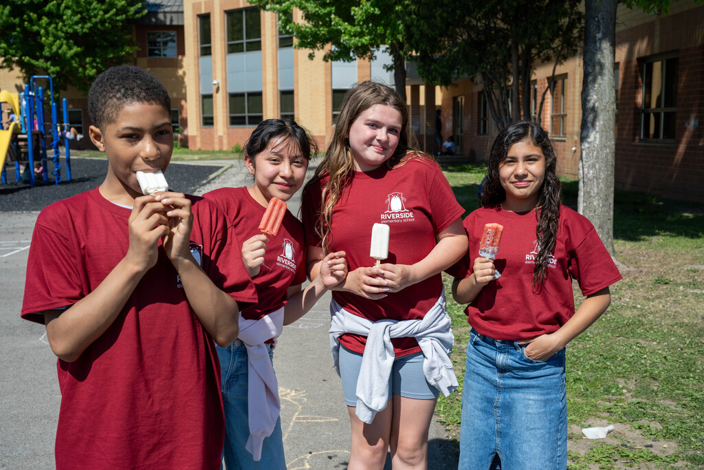 Kids in red shirts enjoying a treat