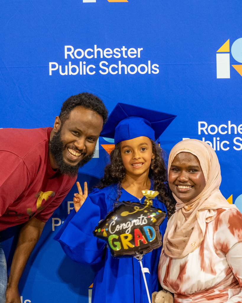 family of preschool graduate smiling at the camera