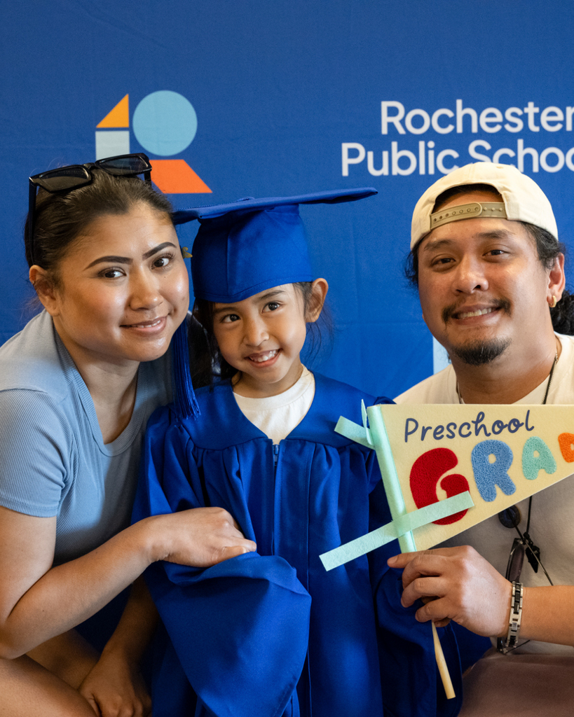 family of preschool graduate smiling at the camera