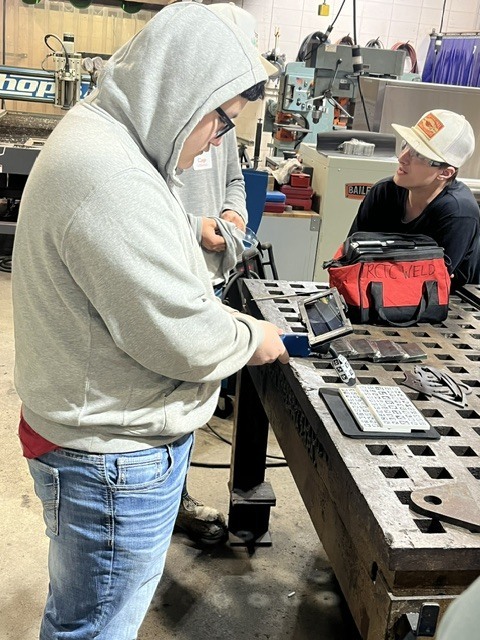 Joel taking his hand at the welding simulator
