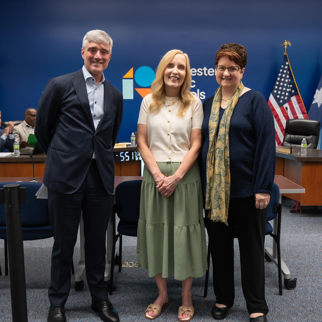 Retiree standing with Dr. Kent Pekel and Cathy Nathan.