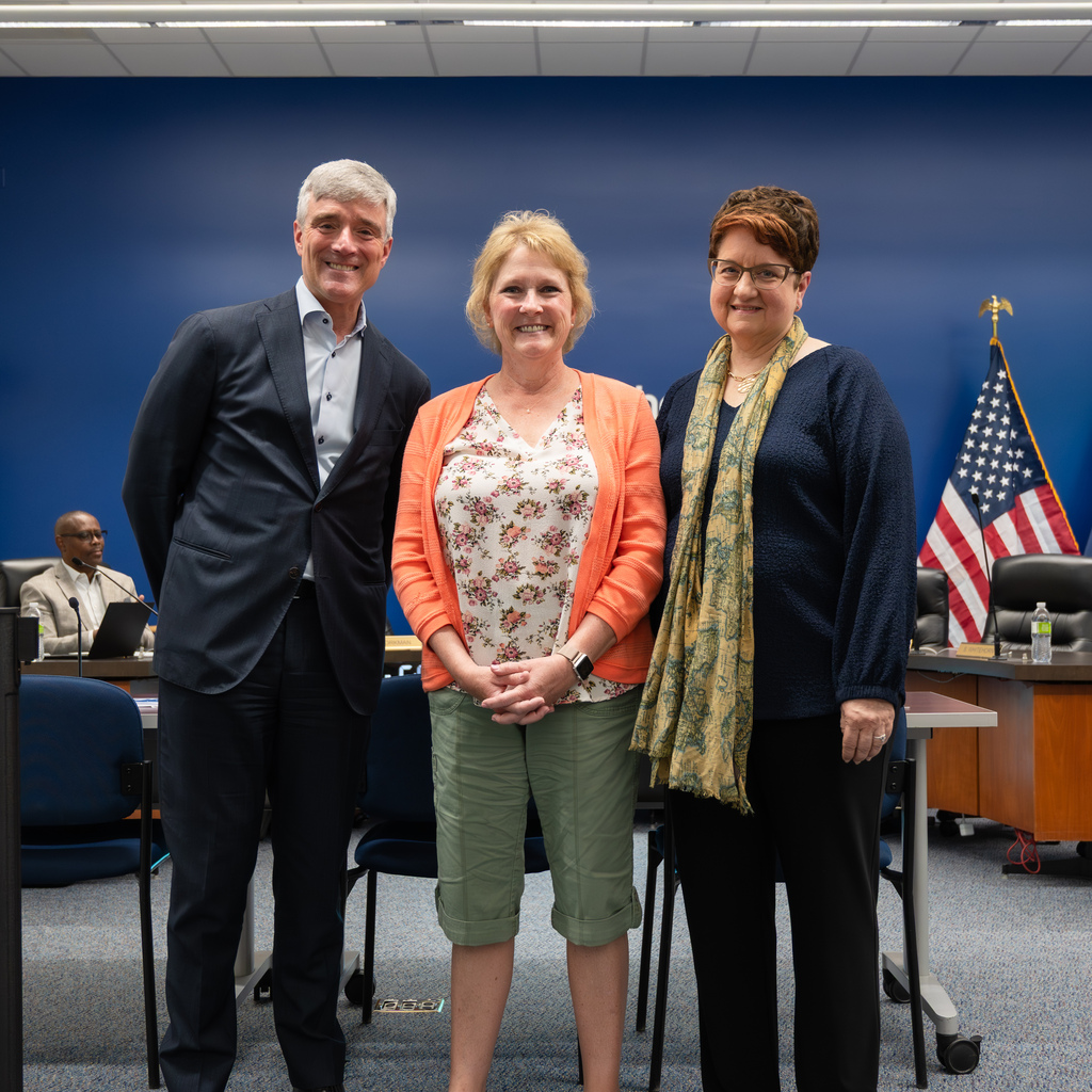 Retiree standing with Dr. Kent Pekel and Cathy Nathan.