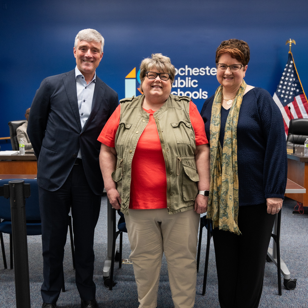 Retiree standing with Dr. Kent Pekel and Cathy Nathan.