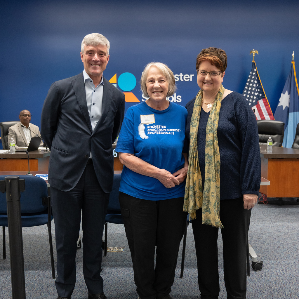 Retiree standing with Dr. Kent Pekel and Cathy Nathan.