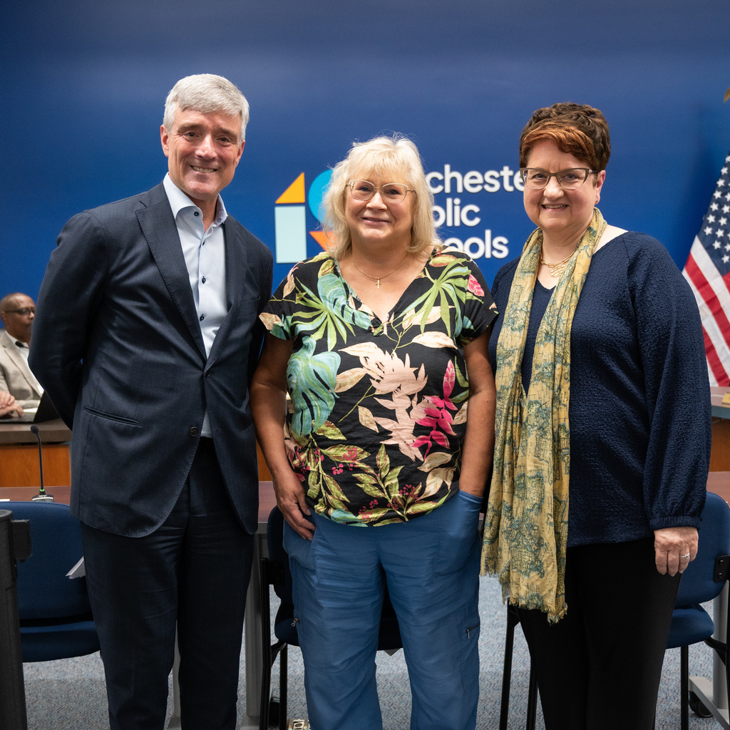 Retiree standing with Dr. Kent Pekel and Cathy Nathan.