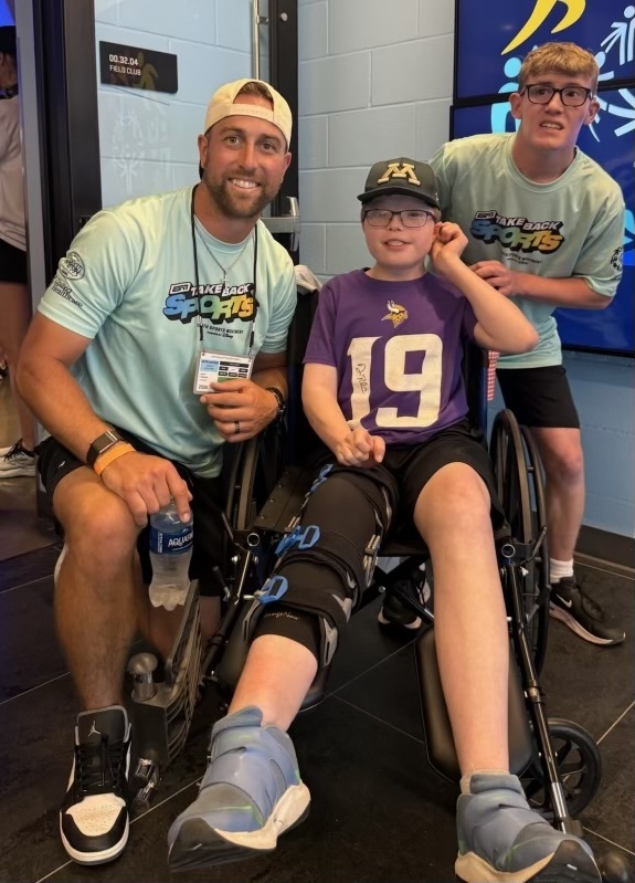 Unified student posting with an olympian for a photo in a Take Back Sports Shirt.