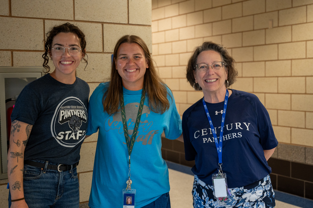 Three Century staff members embracing with arms around their backs smiling for a photo.