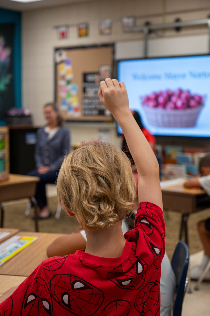 A Riverside student raises their hand to ask a question to Mayor Kim Norton