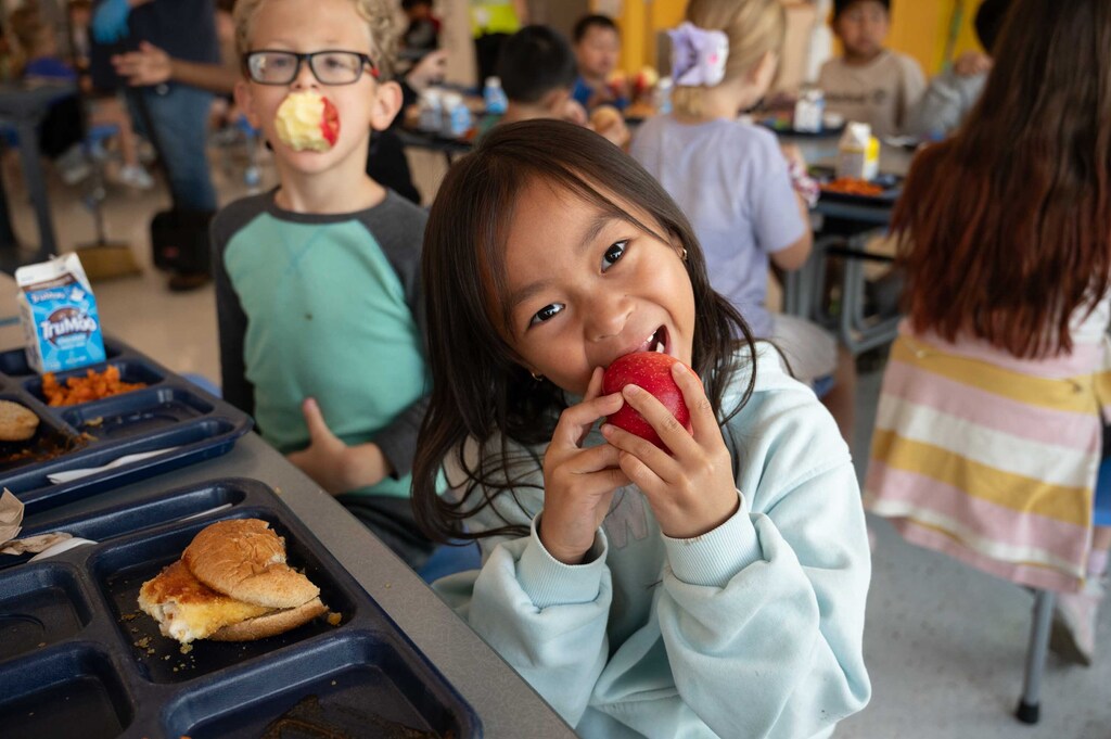 Student crunching into an apple