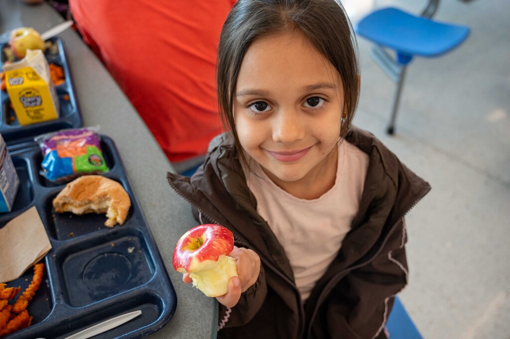 Student showing their apple to the camera