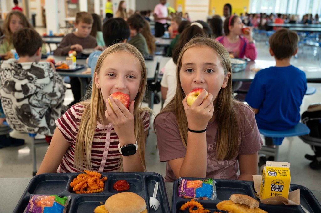 Students crunching into an apple