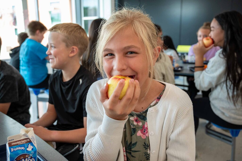 Student crunching into an apple