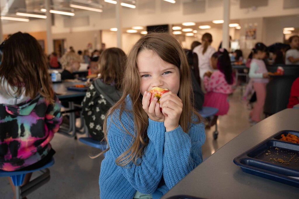 Student crunching into an apple