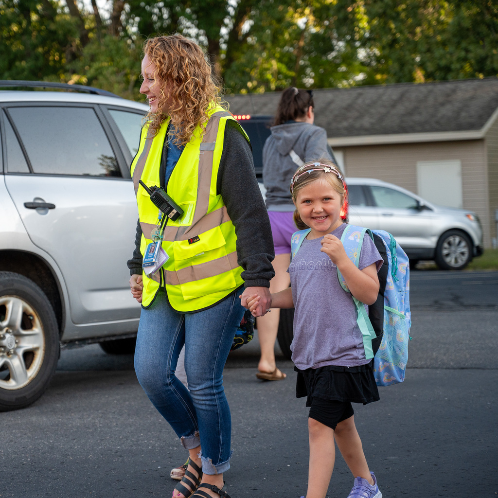 Kid walks with adult to school
