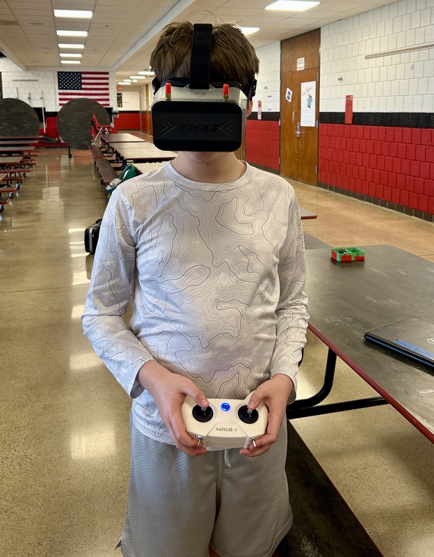 Student posing with headset on and controller in hand.