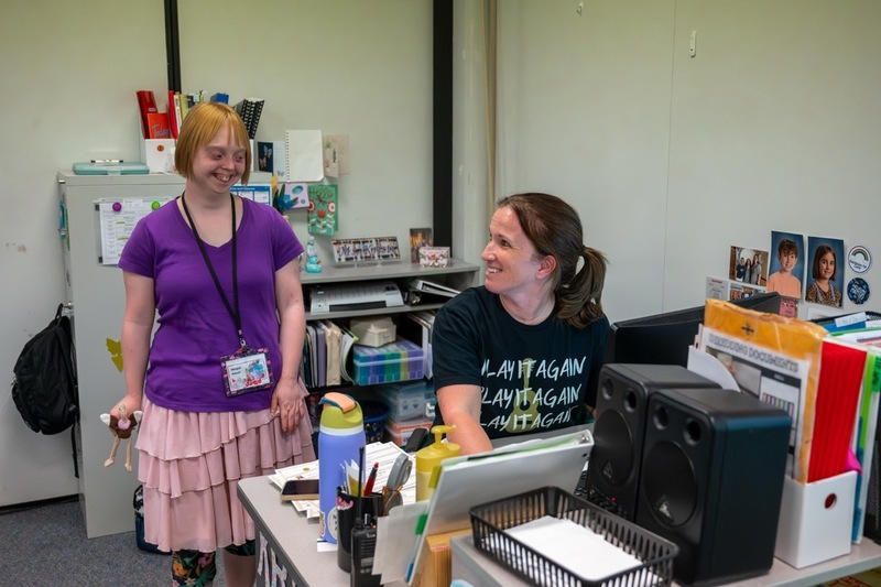 Morgan and Kristi pick a song to practice with at Kirsti's desk