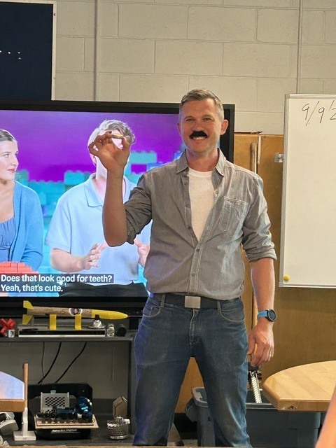teacher displays lego object