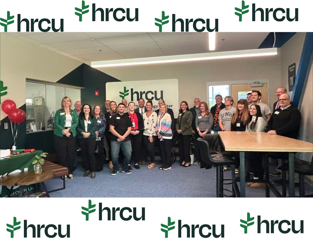 A group of people in a room with a wooden table, balloons, and a sign with "hrcu" on it.