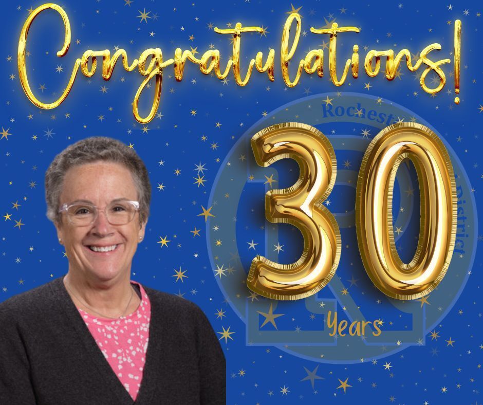 Woman wearing glasses and a black cardigan smiles against a blue background with golden "Congratulations! 30 Years" text.
