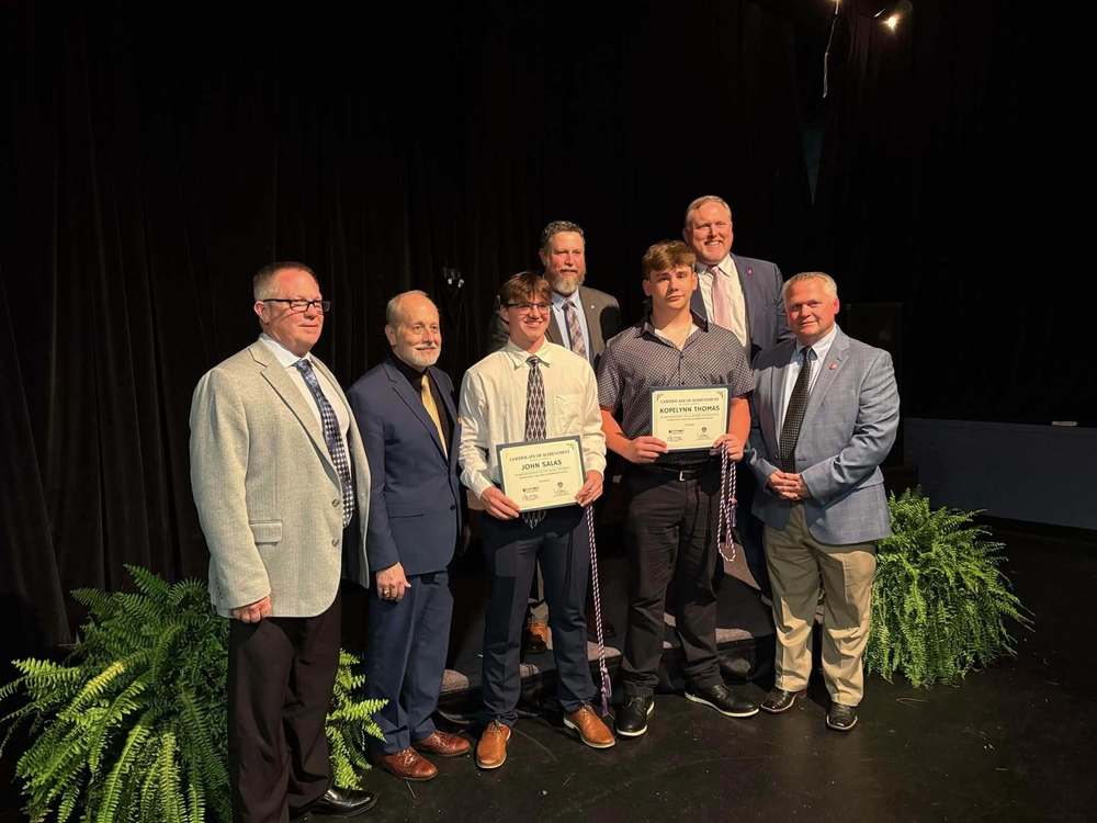people smiling on stage with their awards