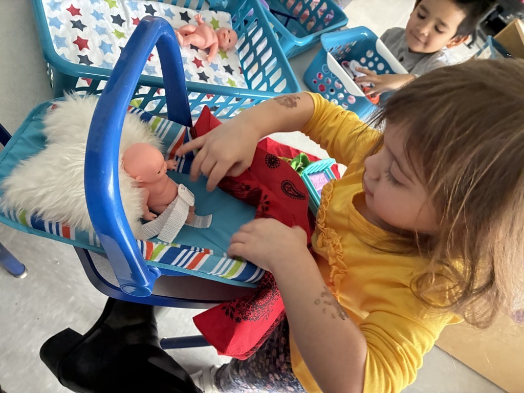 Birchwood Future Doctors are on call... picture of student dressed up as  a doctor with a doll on her toy  carseat 