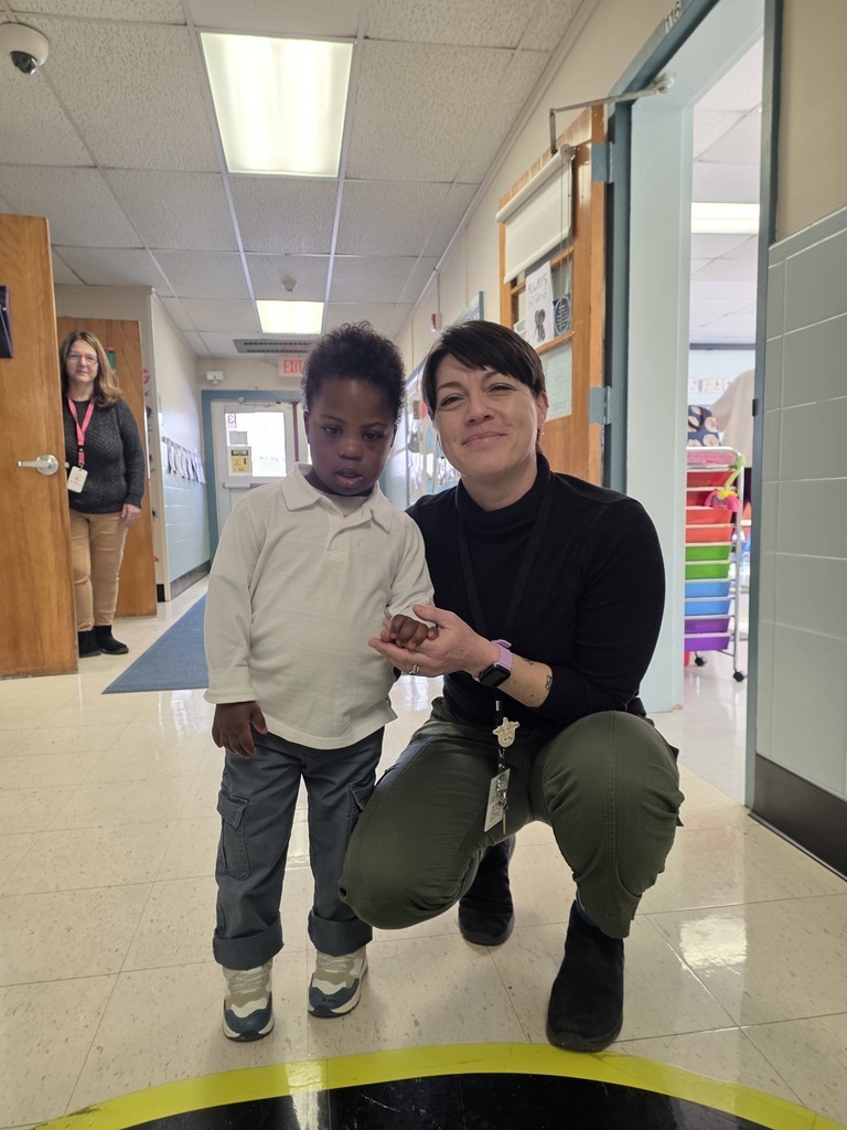 student and teacher posing in the school hallway 