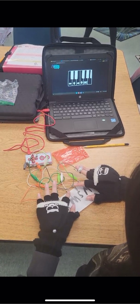 picture of a chromebook, students hands while  working on 5th Graders in Mr. Titus' science class explored Makey Makey; Using a circuit board, alligator clips, and a USB cable, the toy uses closed loop electrical signals to send the computer a keyboard stroke making a familiar tune! Great job!🐬♥️ #SBhasHEART