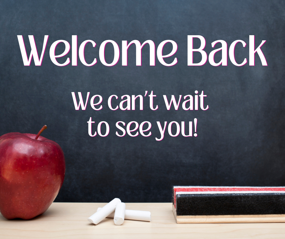 The words "Welcome Back, we can't wait to see you" are in print against a chalkboard background. They appear in white font. An apple, an eraser, and pieces of chalk also appear, as if sitting on a teacher's desk.