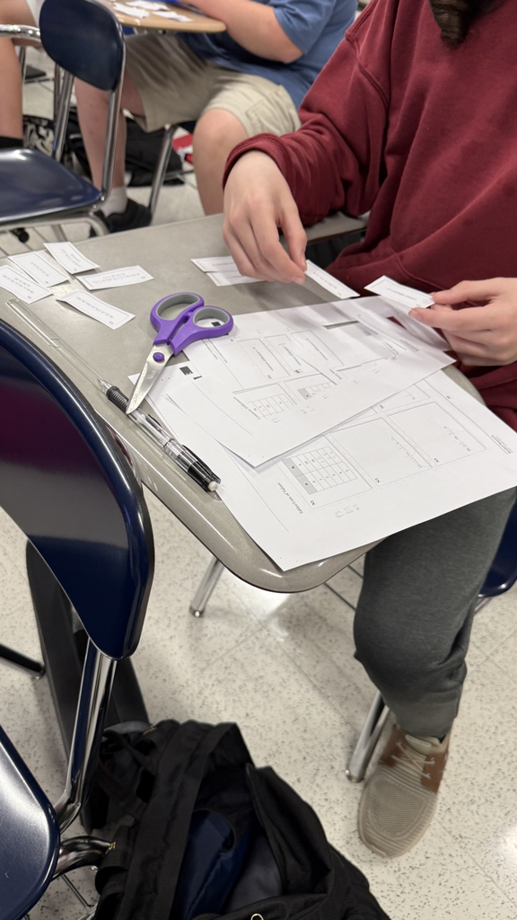 Students cutting strips of paper.
