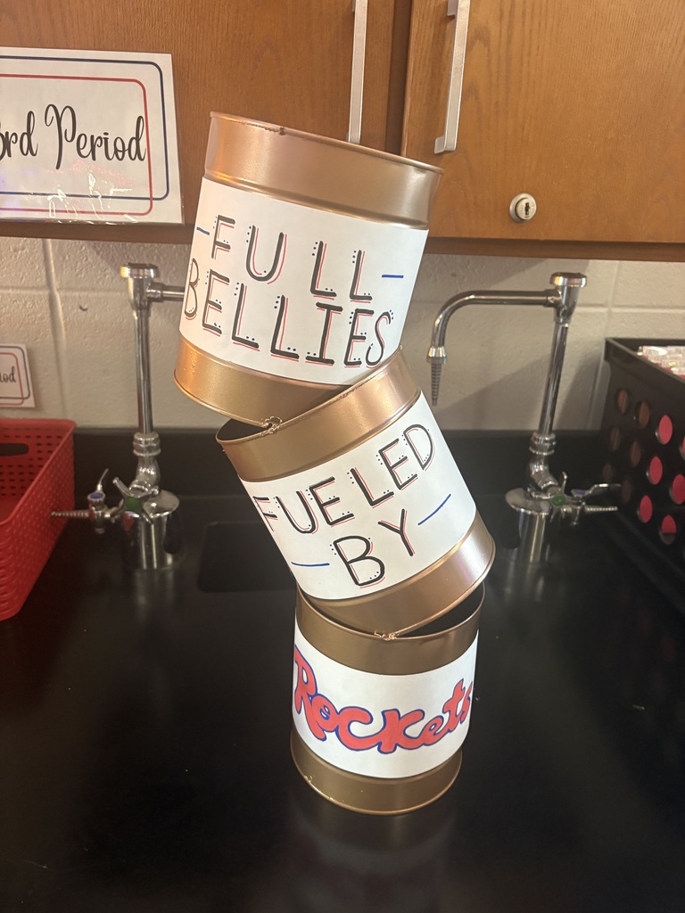 A trophy made of stacked coffee cans painted gold.