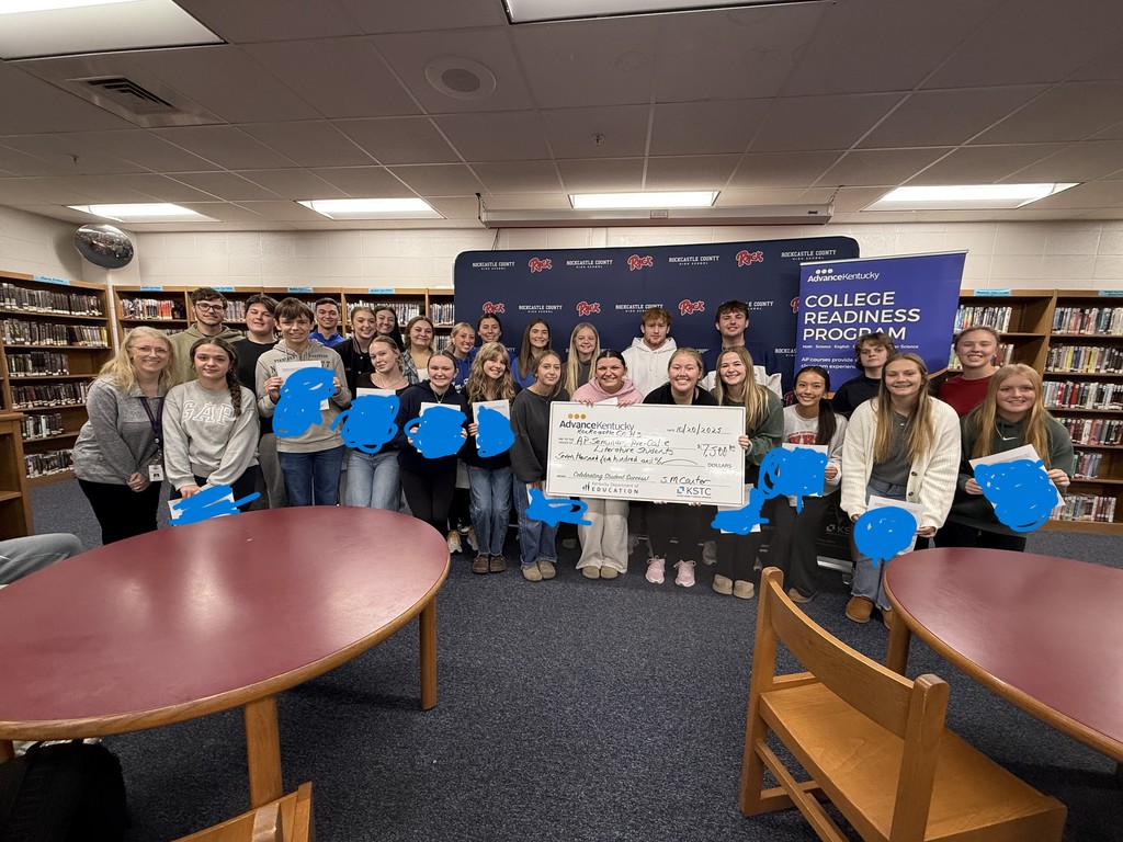 Students pose with a large check. 