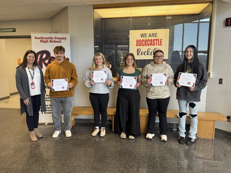 Students stand with certificates