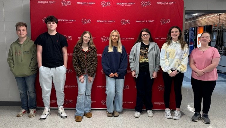 Students stand in front of a locker  