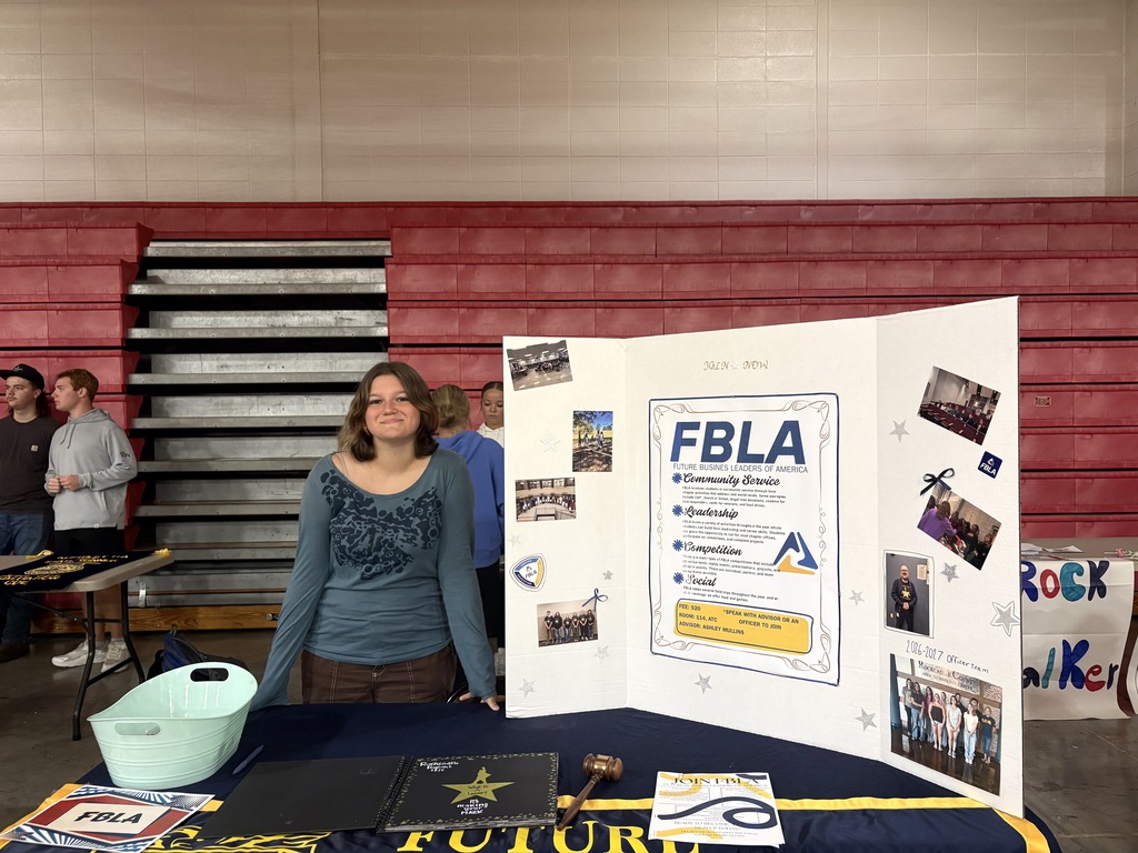Student stands beside a large poster board display
