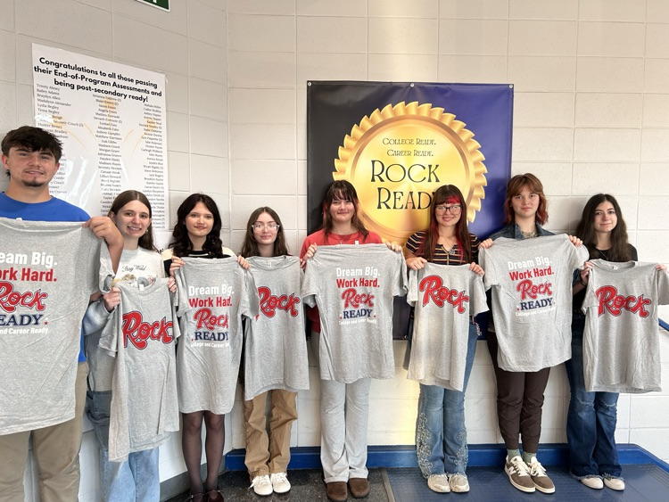 Students stand holding t-shirts