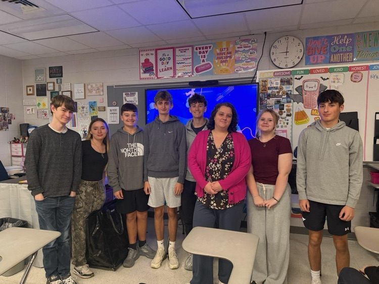 Mrs. Faust stands in her classroom with students standing on both sides 