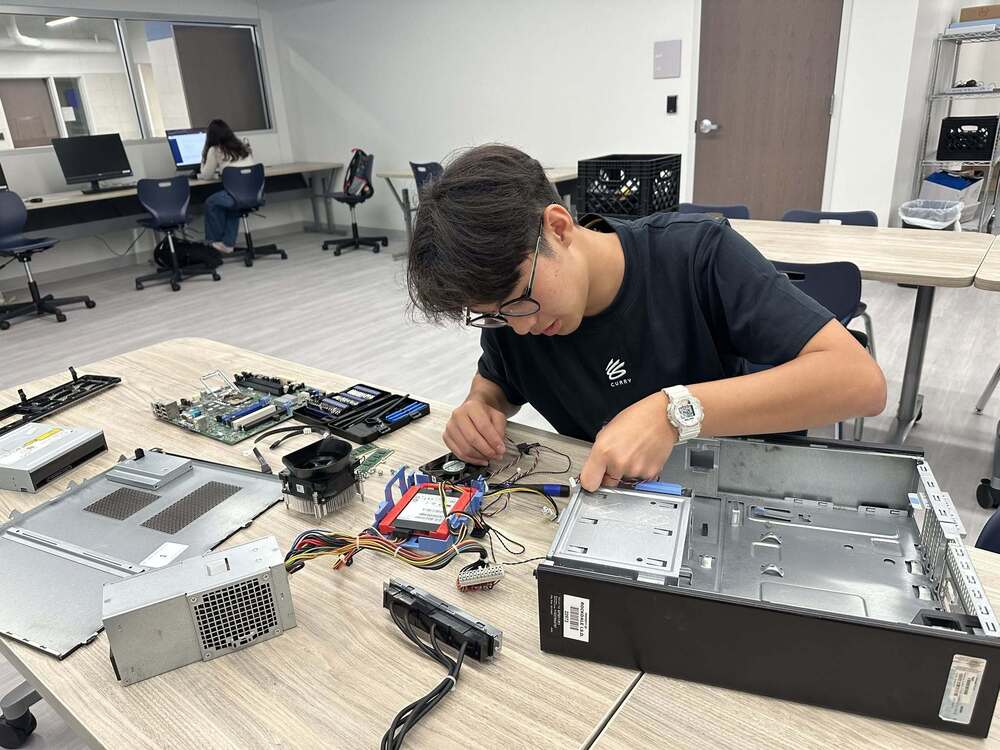 Student taking apart a computer monitor.