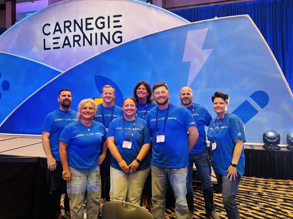 Group picture of people in blue shirts smiling.