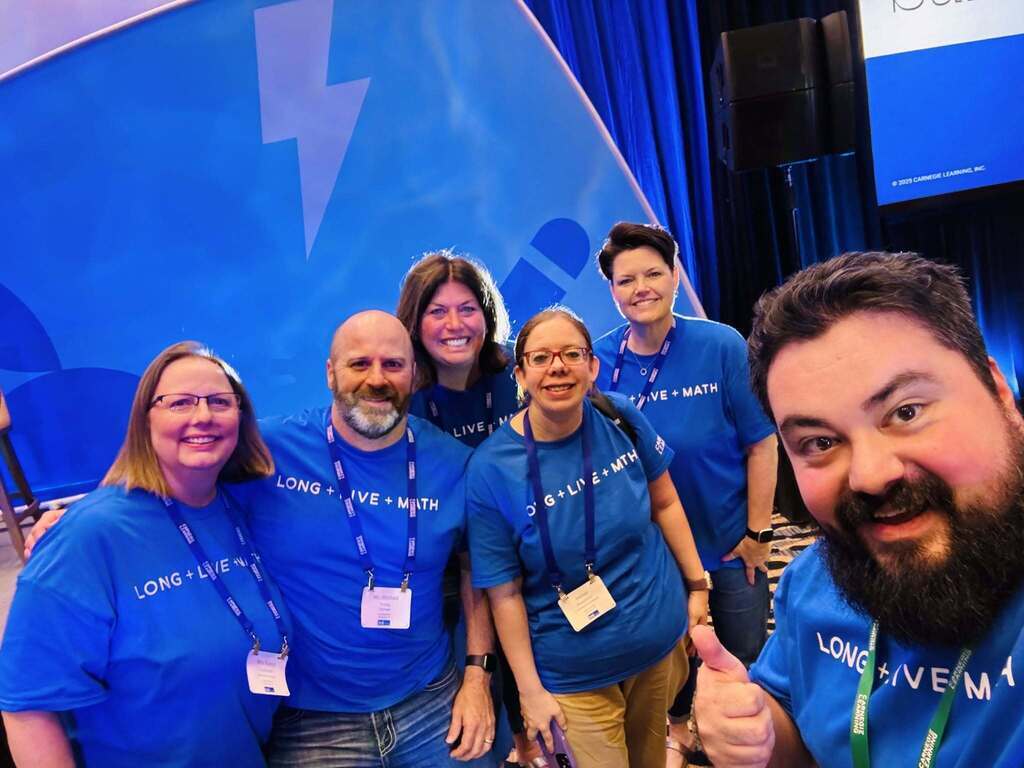Group picture of people in blue shirts smiling.