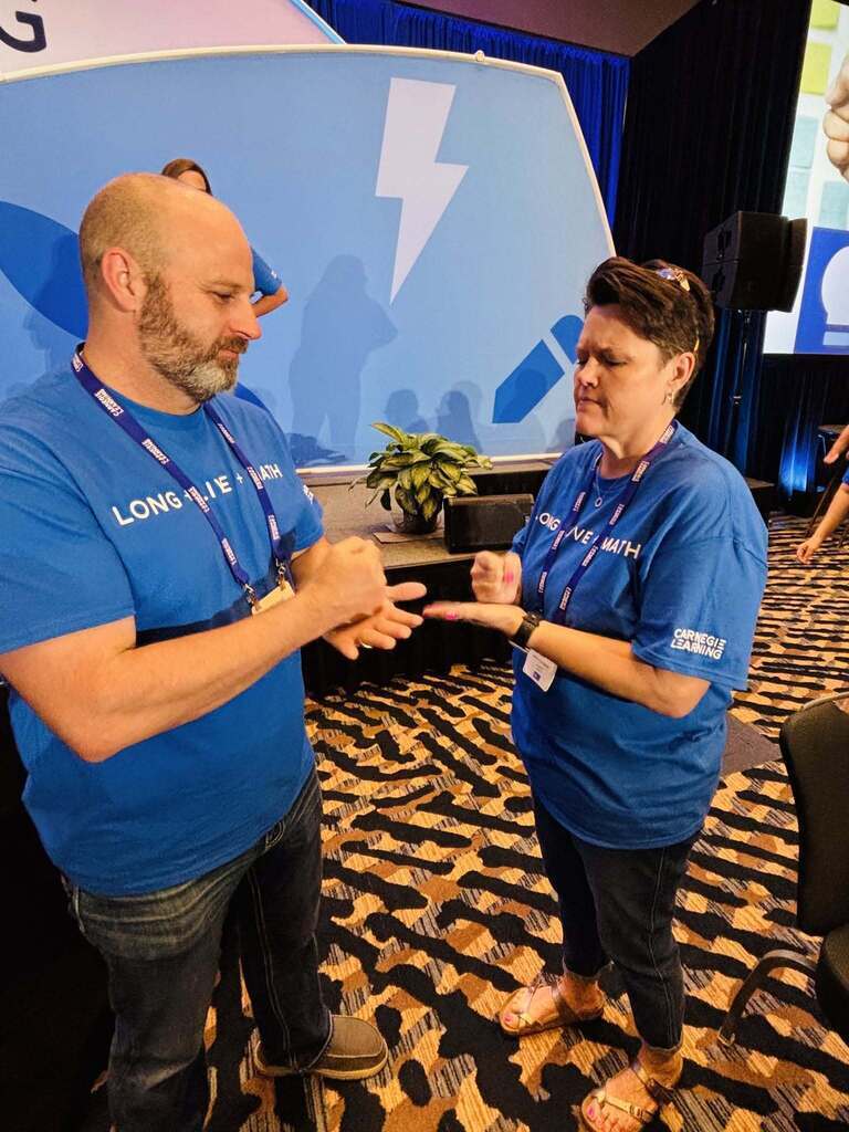 Picture of man and woman in blue shirts play rock, paper, scissors.