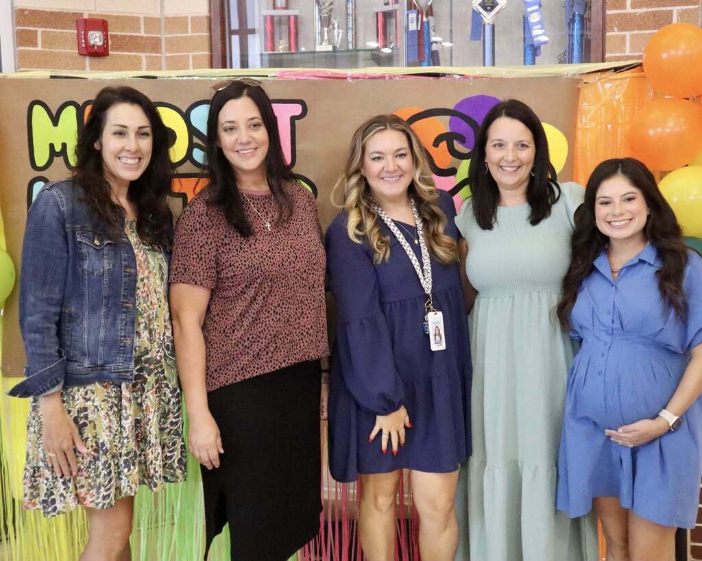 A group of people smiling in front of a sign that says "Mindset Matters"