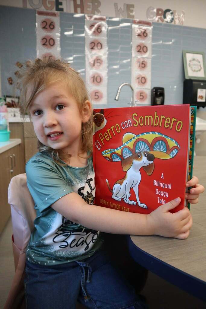 Elementary student sitting down holding a book